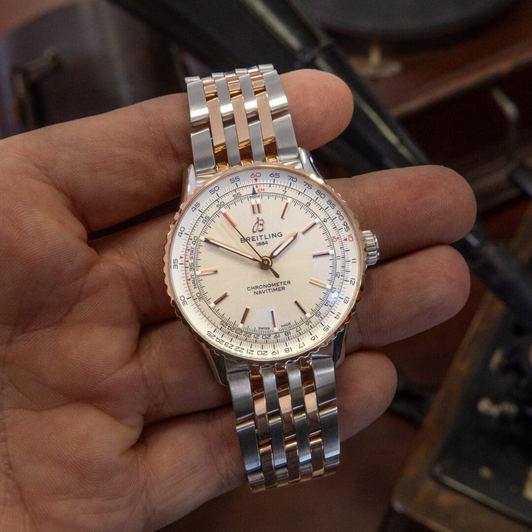 A hand holding a luxury wristwatch.