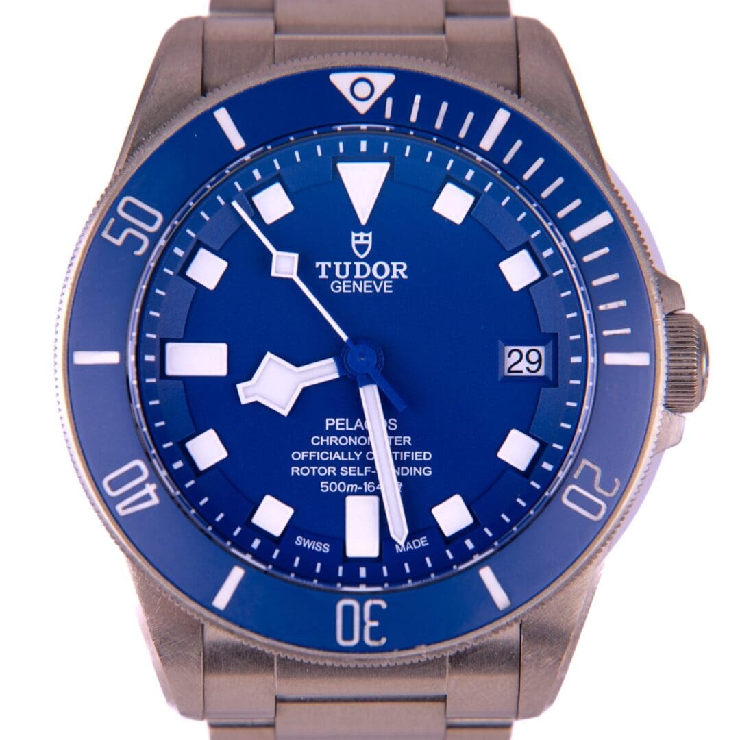 Blue Tudor dive watch with metal bracelet.