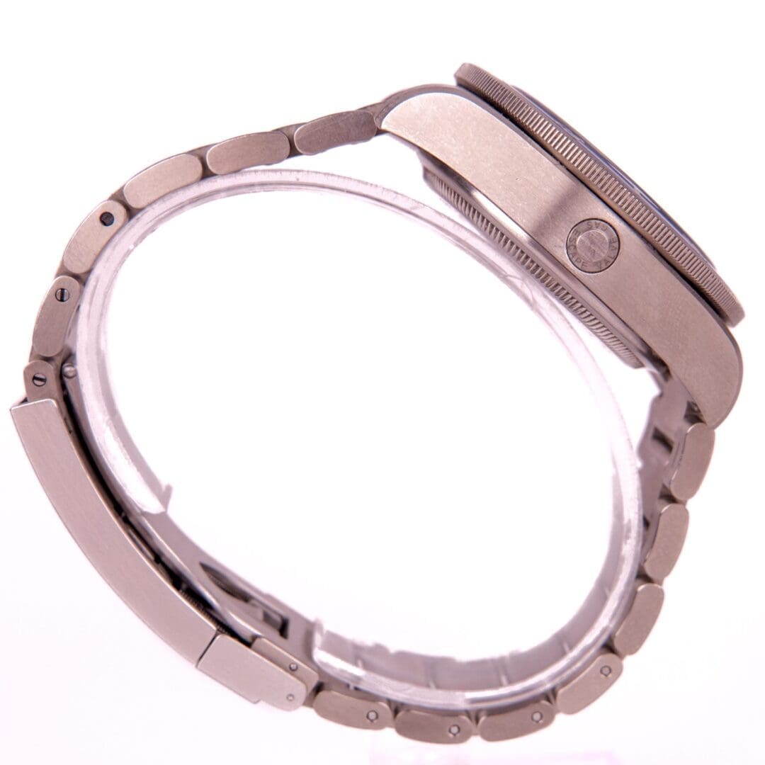 Silver wristwatch with metal band, side view.