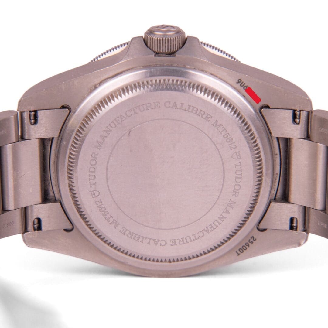 Watch back with engraved text and markings.