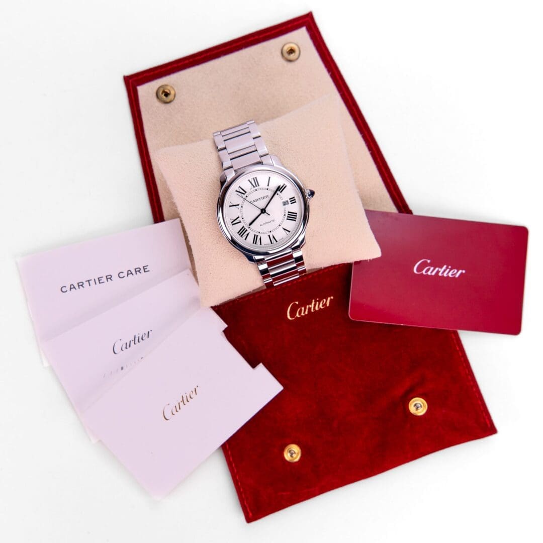 Cartier watch with red case and documents.
