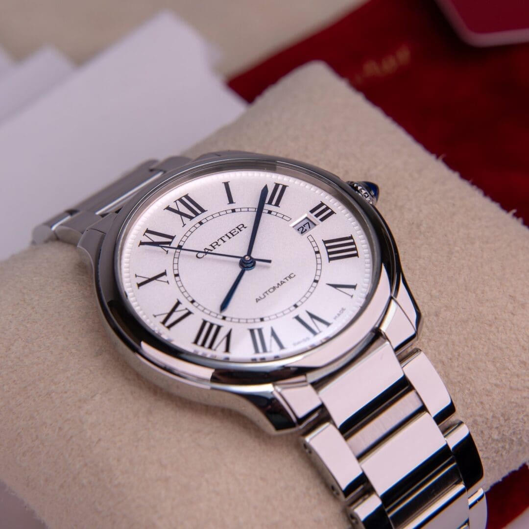 Silver wristwatch with Roman numerals on display.