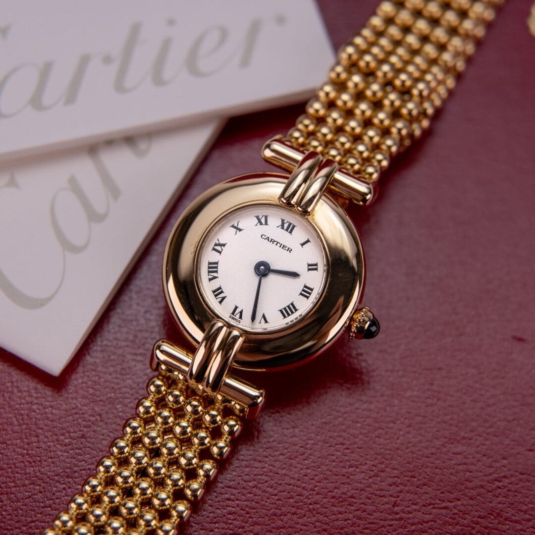 Gold watch with Roman numeral dial.