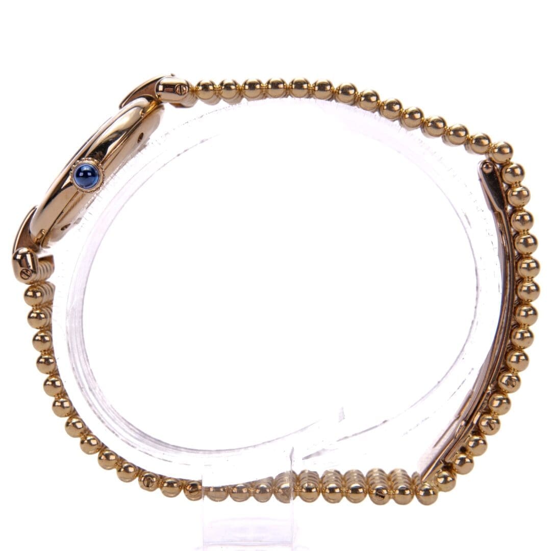 Gold watch with blue gemstone crown.
