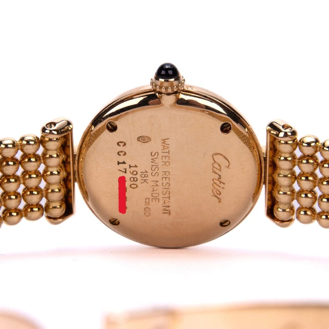 Back of gold Cartier watch with inscriptions.