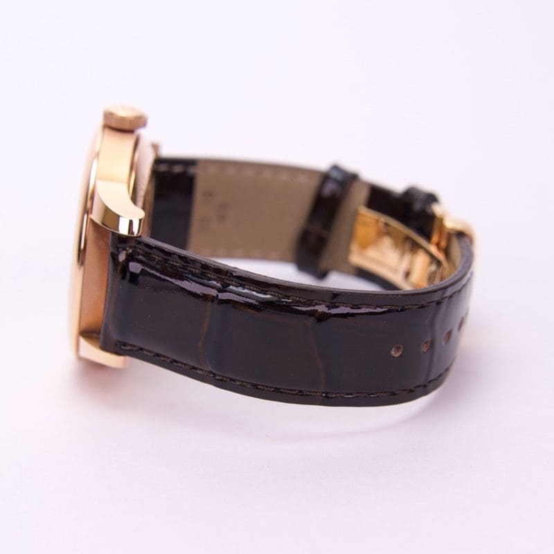 Gold watch with black leather strap.