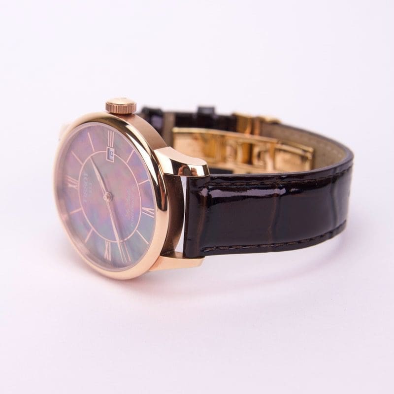 Gold watch with black leather strap.