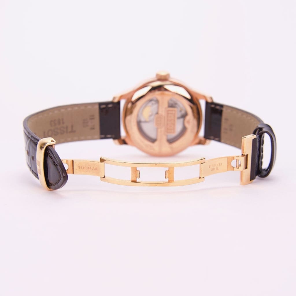 Gold watch with black leather strap.