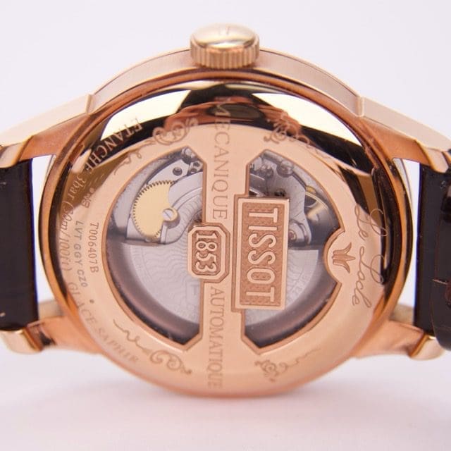 Gold watch with transparent mechanical back.