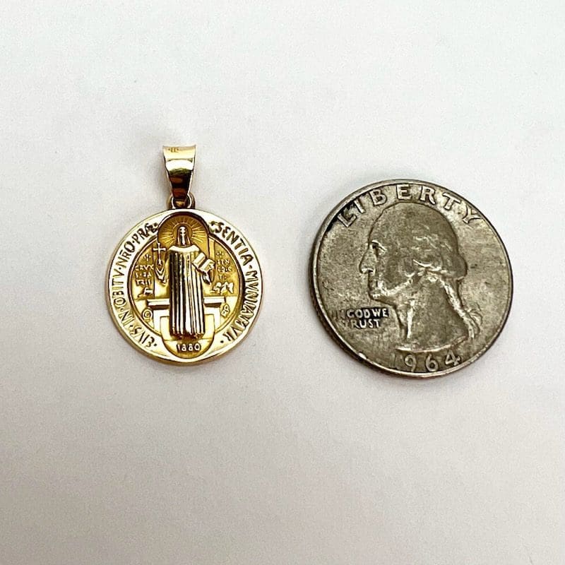 Gold medallion beside a quarter coin.