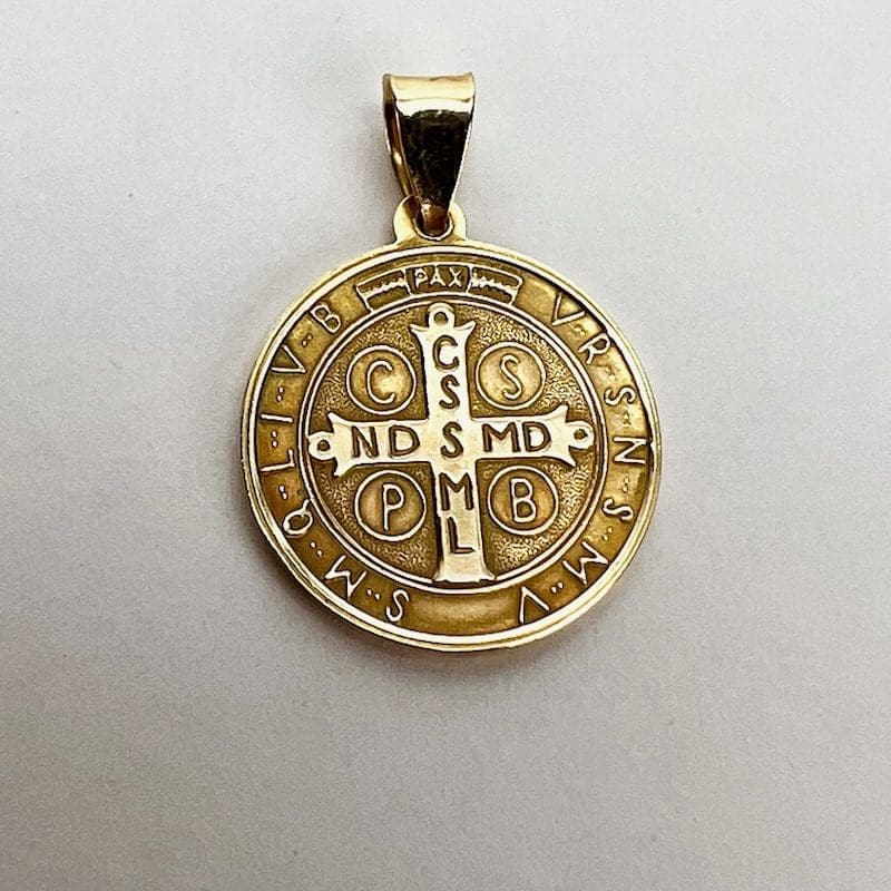 Gold pendant with engraved religious symbols.
