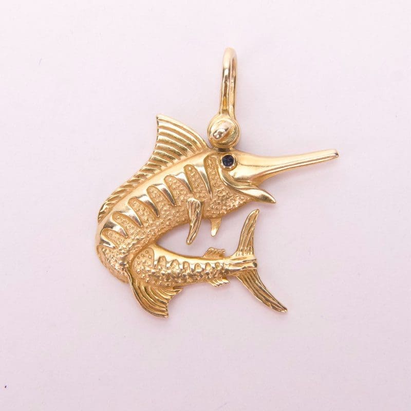 Gold marlin fish pendant with gemstone eye.