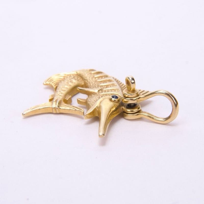 Gold marlin pendant with gemstone eyes.