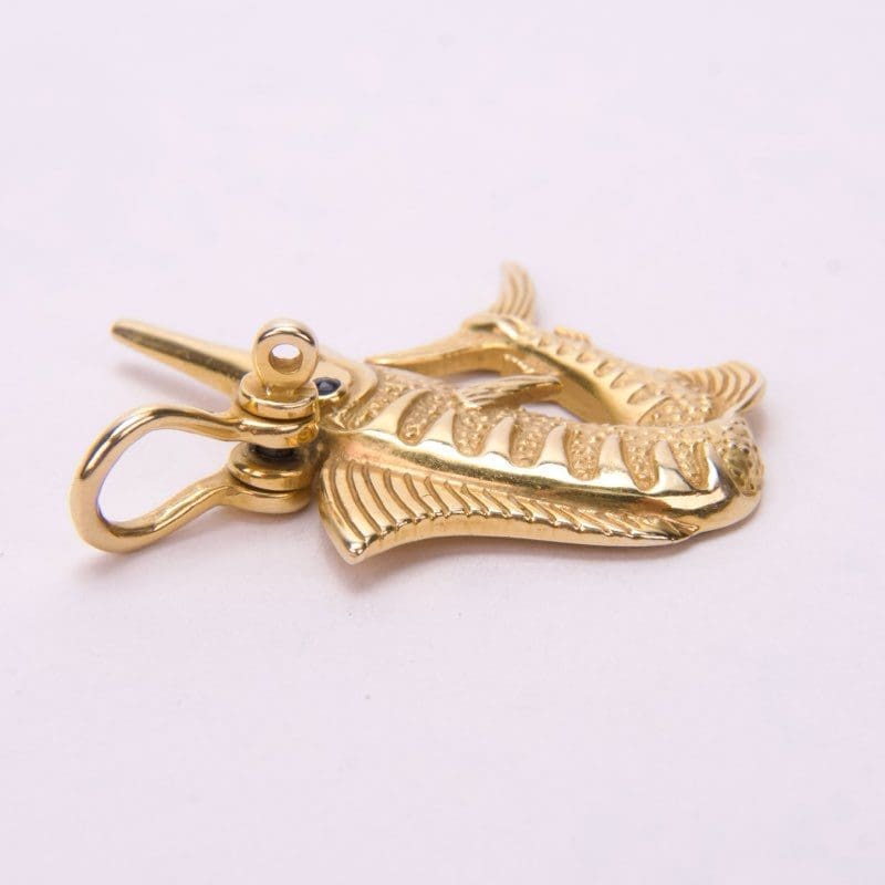 Gold fish-shaped keychain on white background.