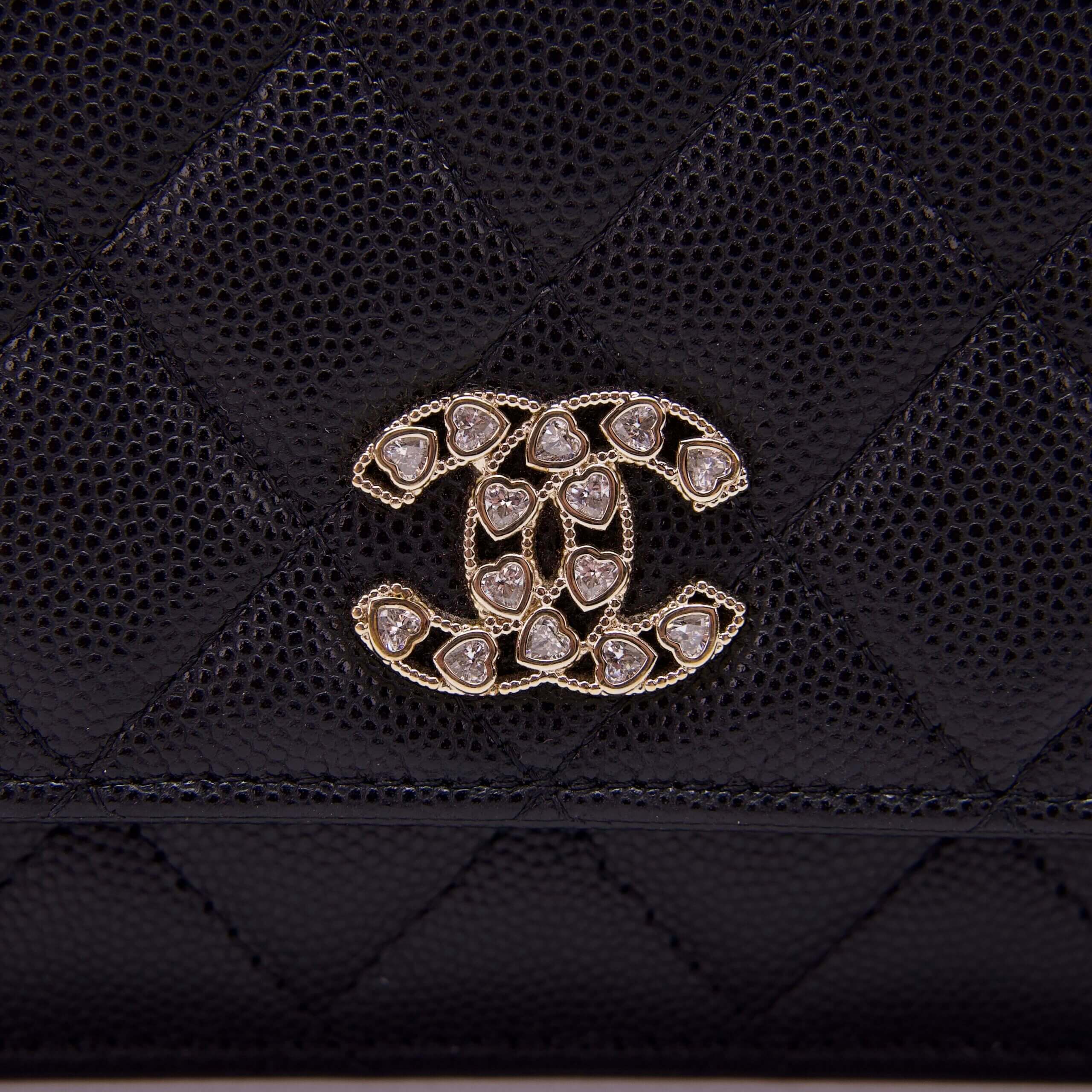 Black quilted bag with embellished logo.