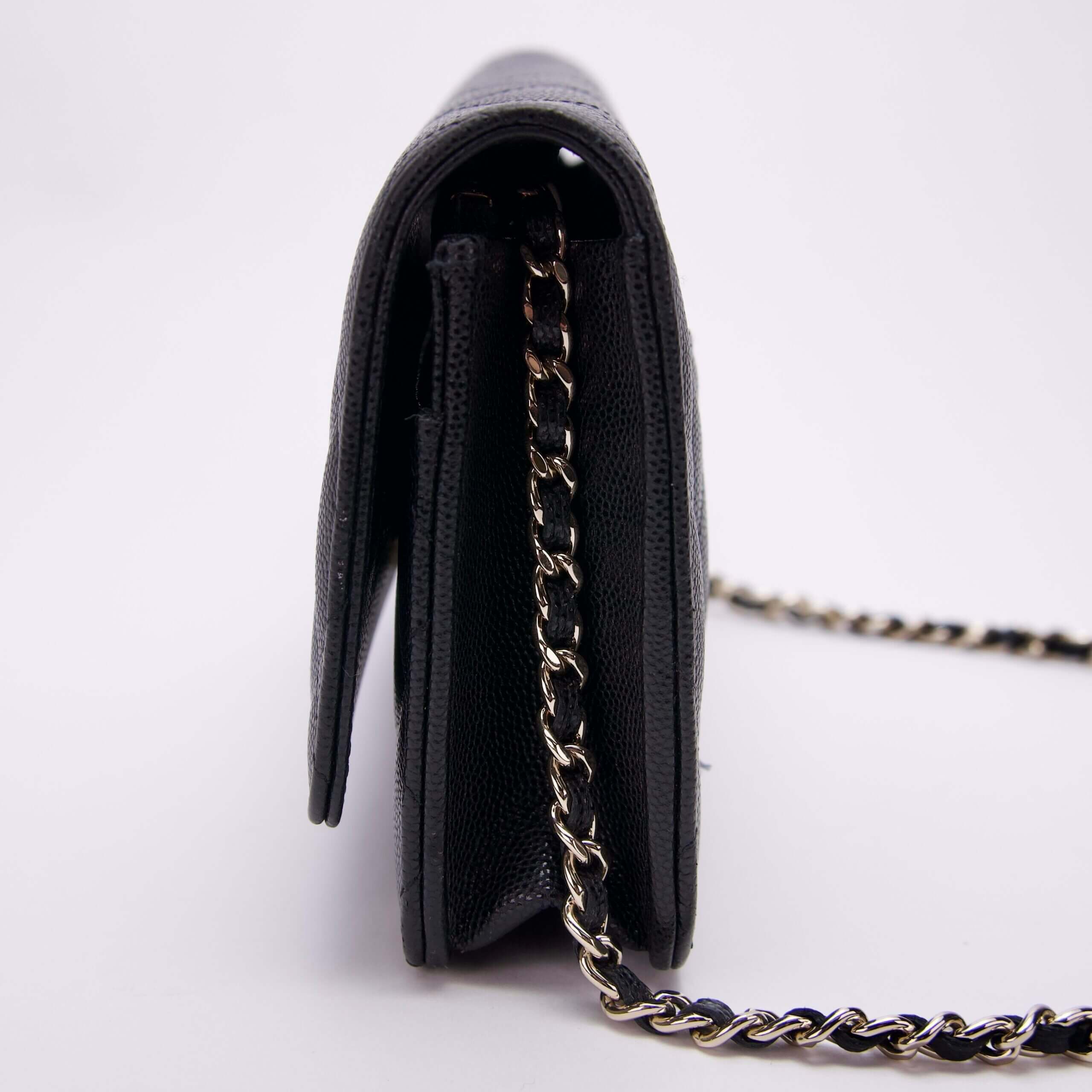 Black handbag with chain strap, side view.
