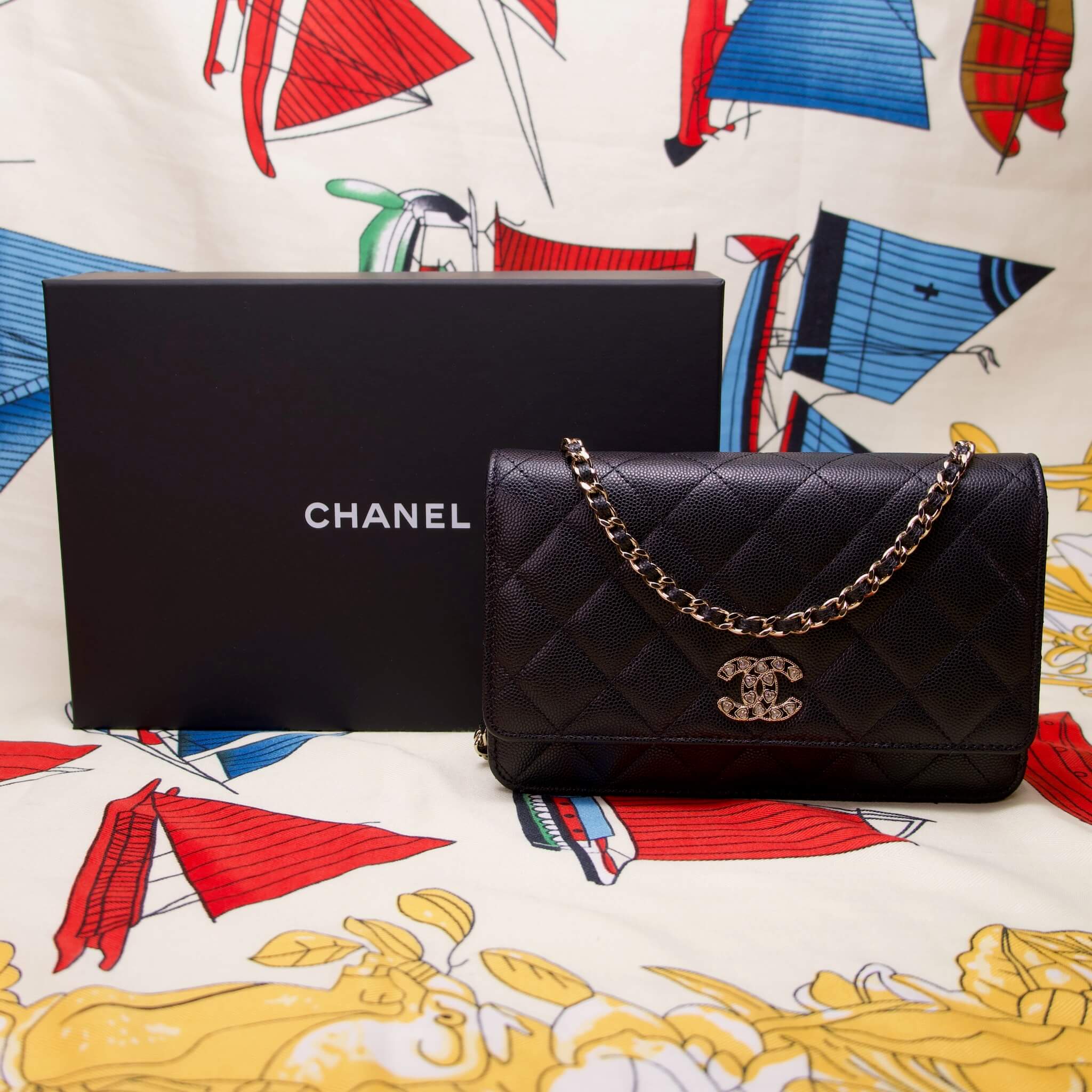 Chanel purse with box on colorful background.