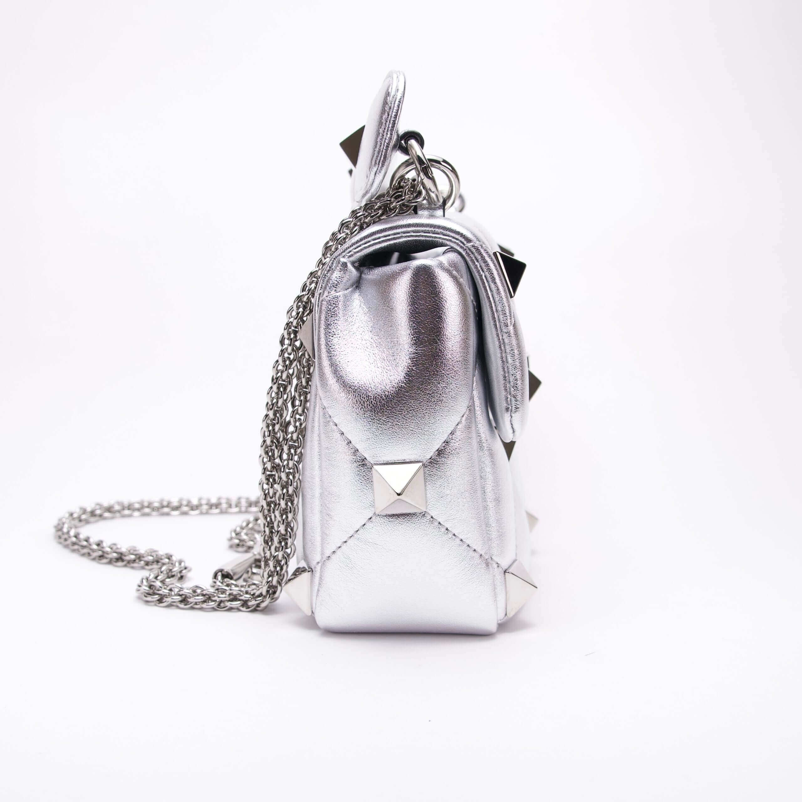 Silver handbag with chain and stud accents.