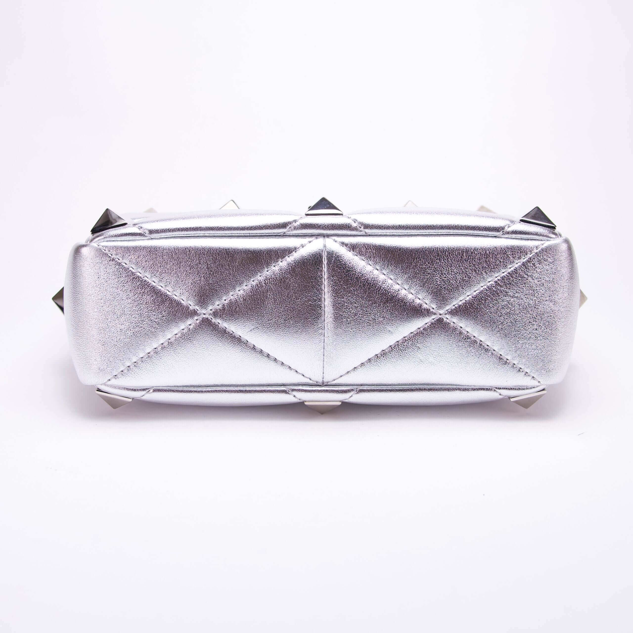Silver geometric clutch with metallic spikes.