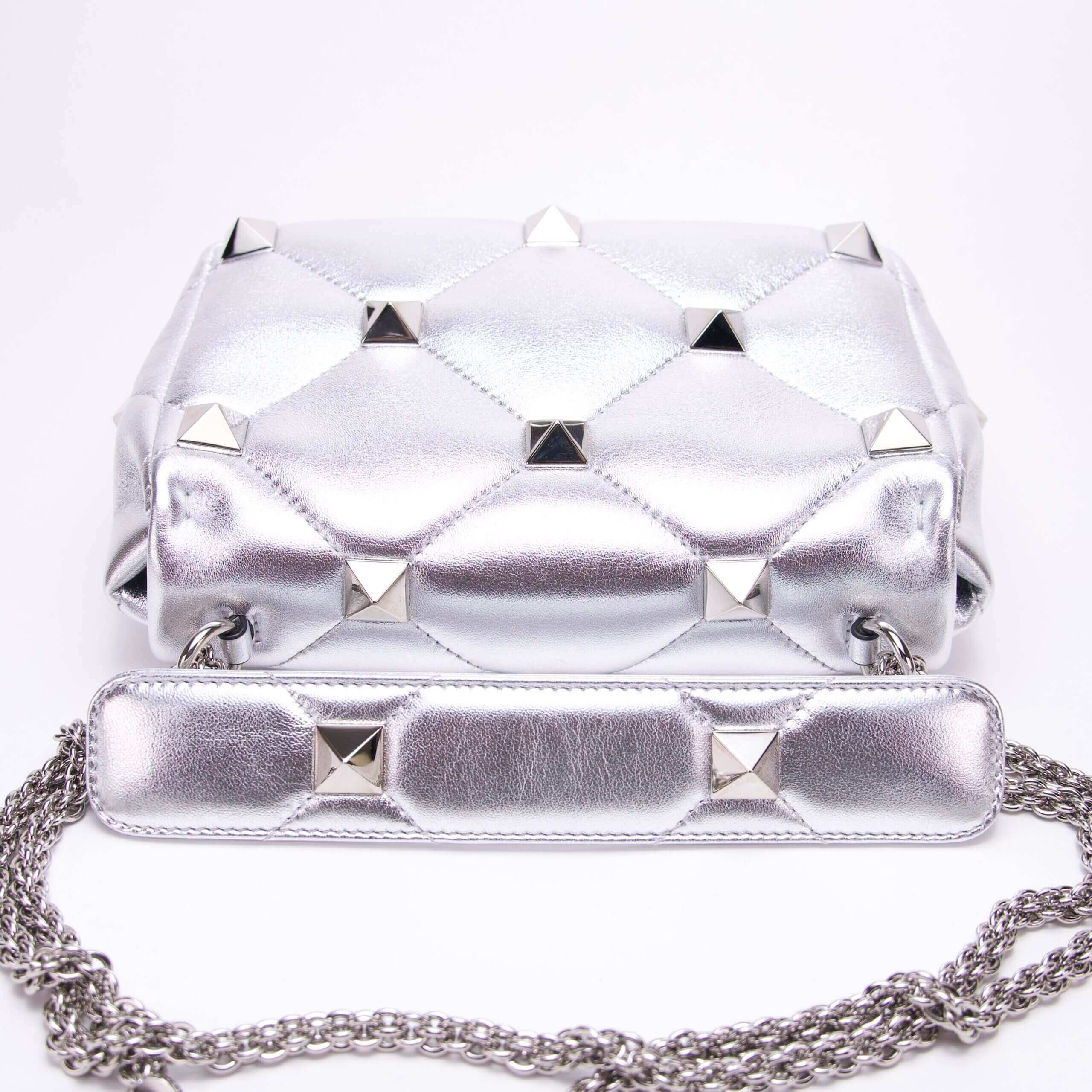 Silver studded handbag with chain strap.