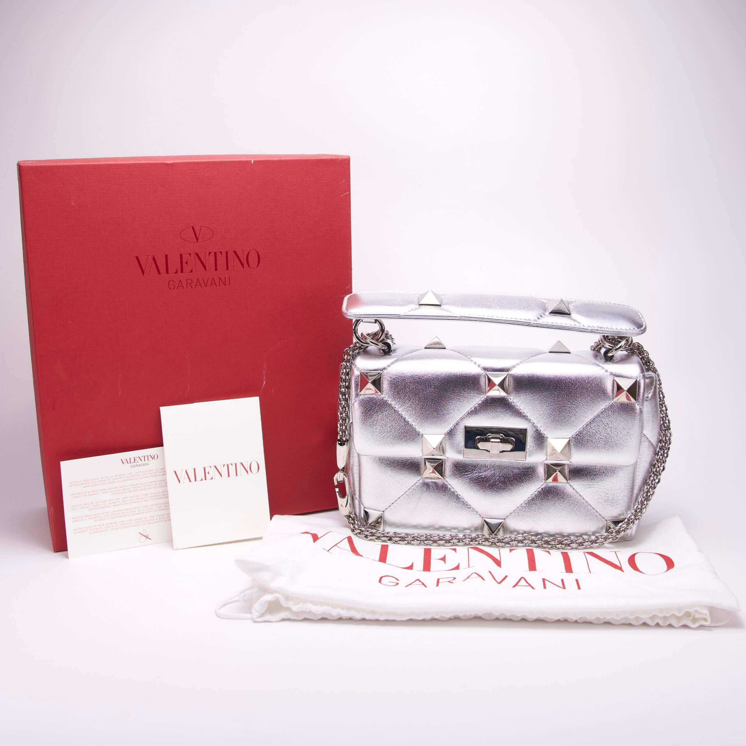 Silver Valentino handbag with red box.