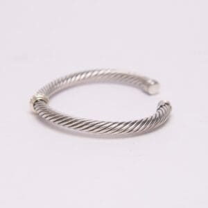 Silver twisted open cuff bracelet on display.