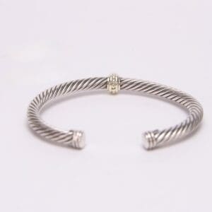 Silver twisted open cuff bracelet on display.