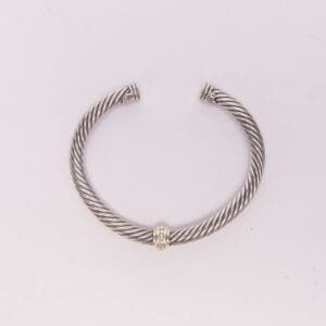 Silver twisted open cuff bracelet on display.