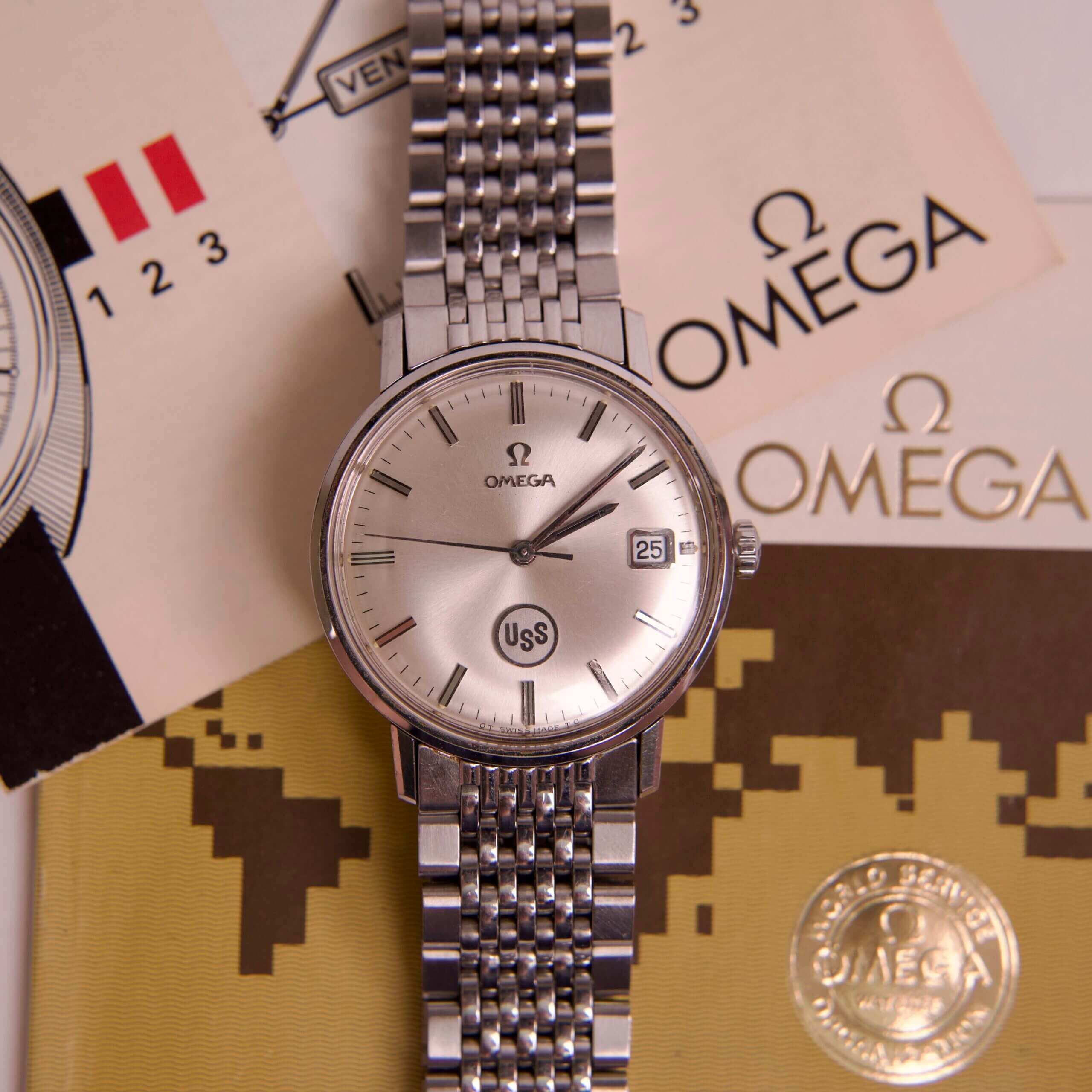 Omega watch with documents and packaging.
