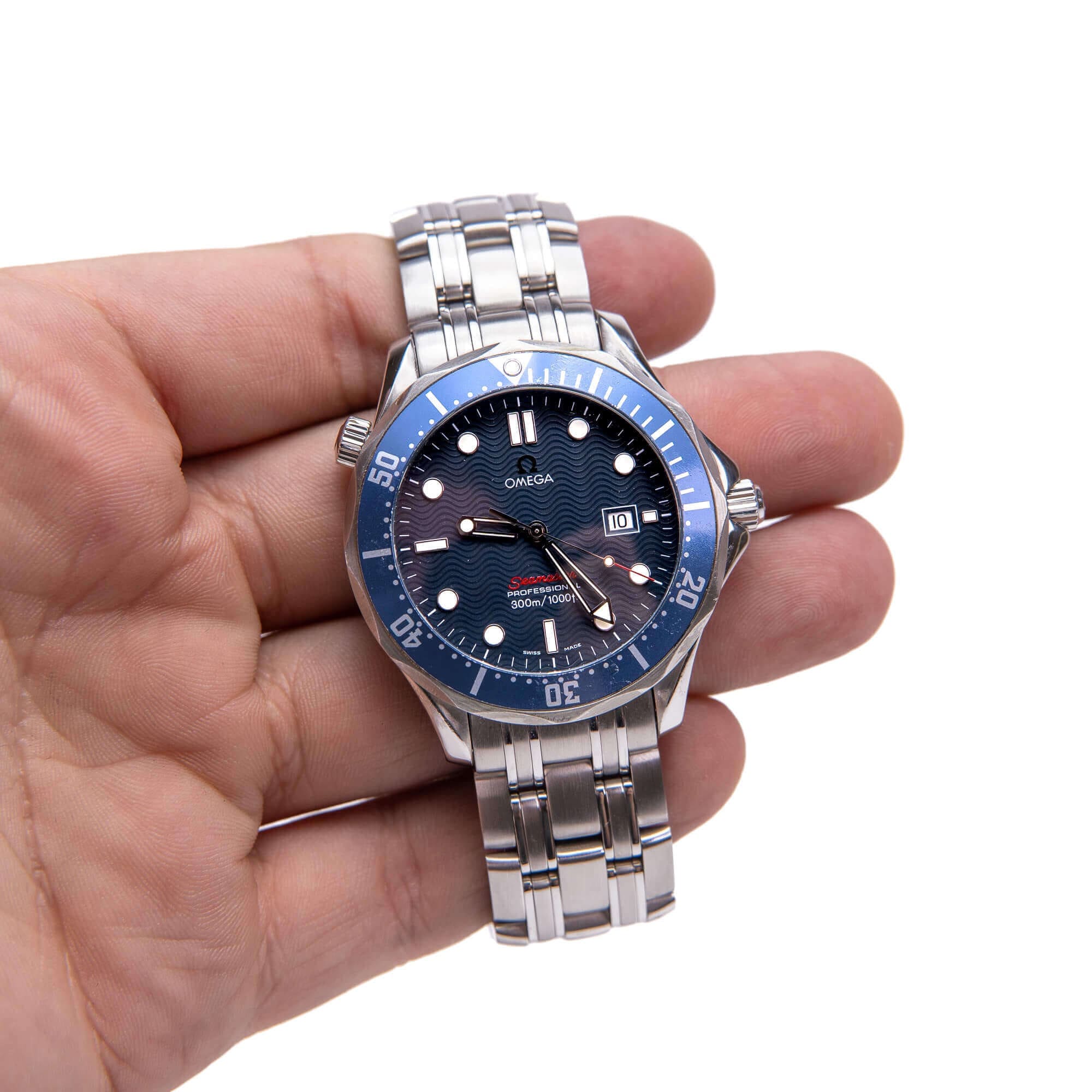 Hand holding a luxury silver wristwatch.