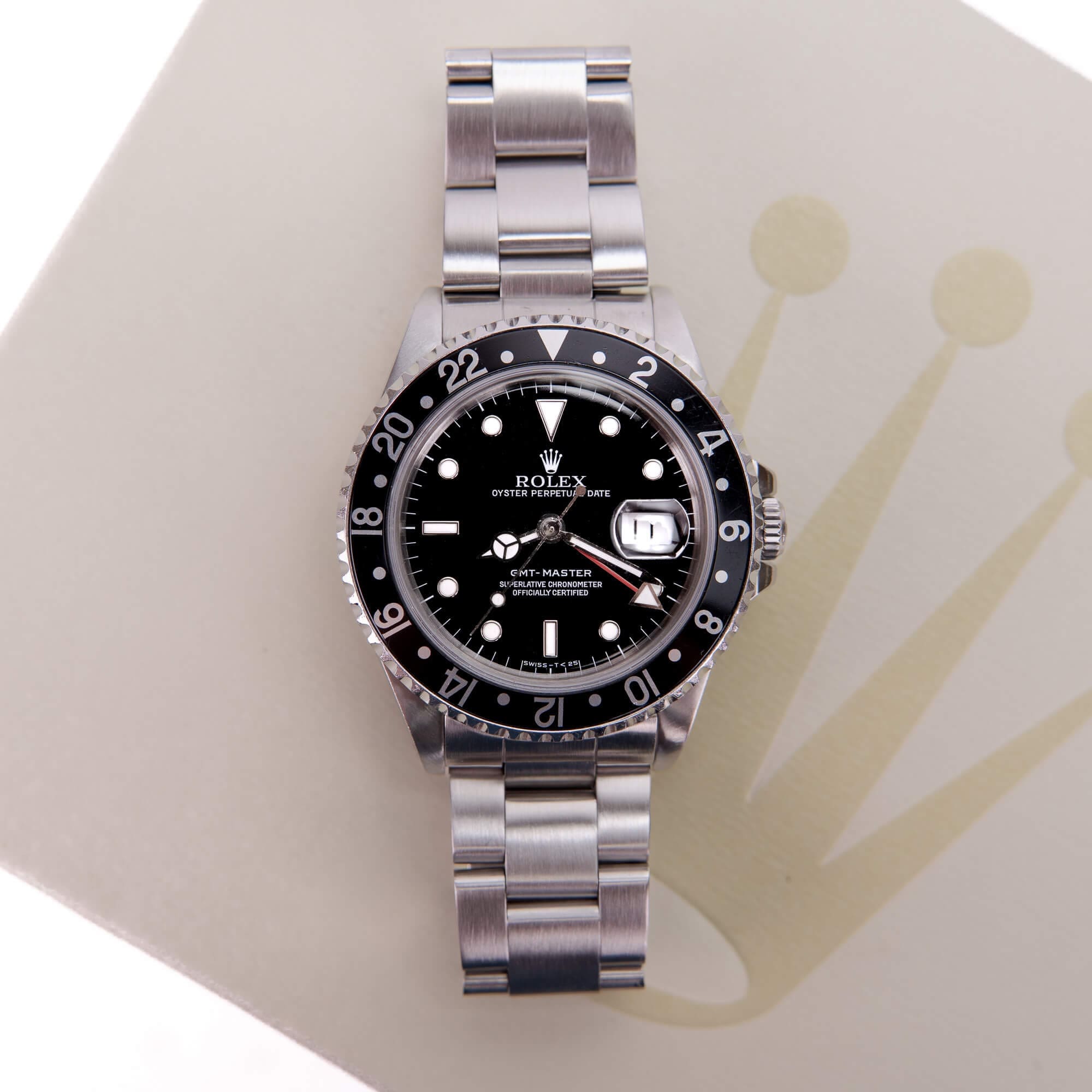 Luxury watch with black dial on box.