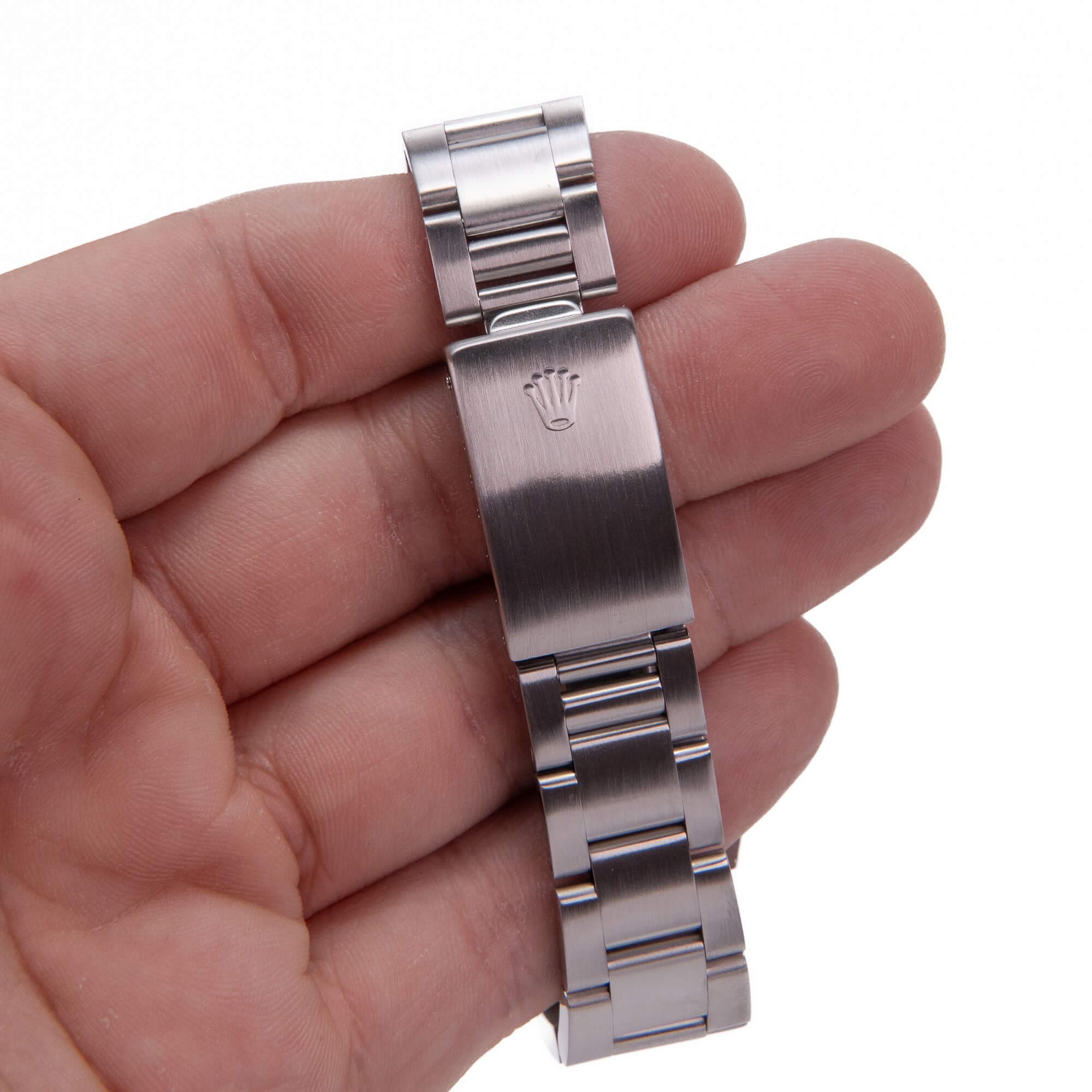 Hand holding a metal watch bracelet.