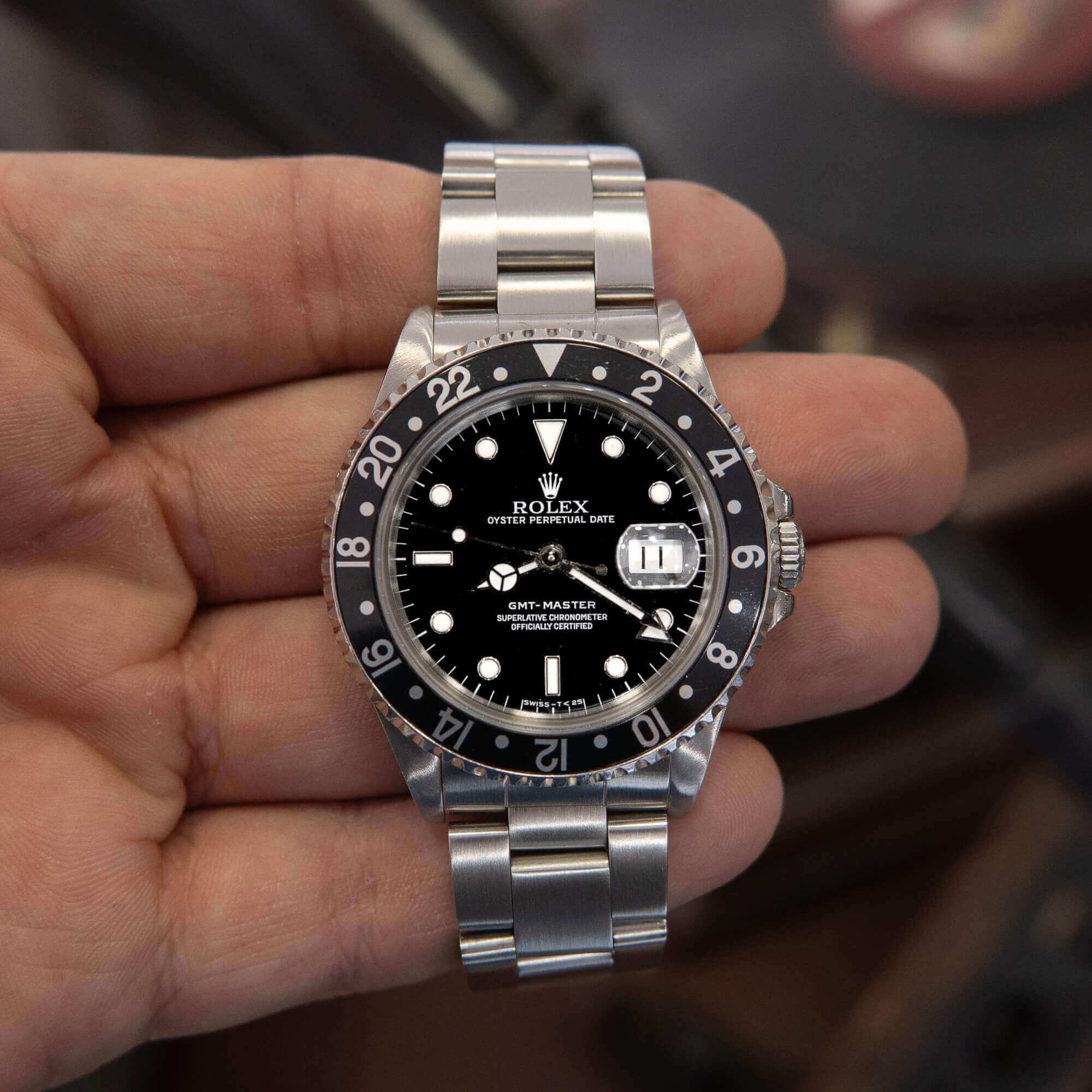 Hand holding a luxury wristwatch.