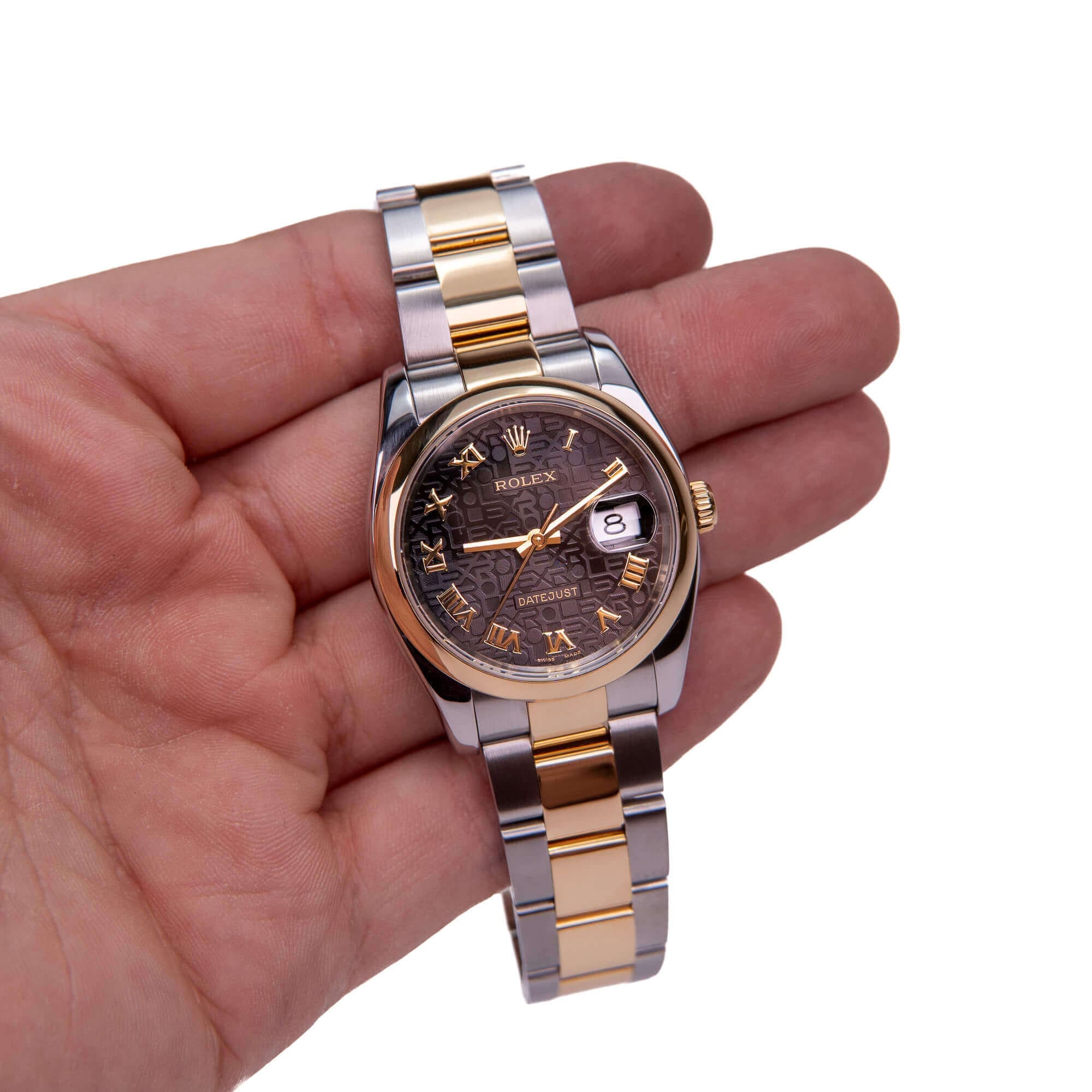 Hand holding a luxury wristwatch with date.