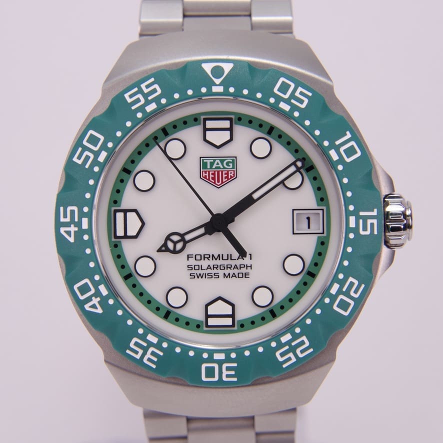 Silver and green TAG Heuer wristwatch.