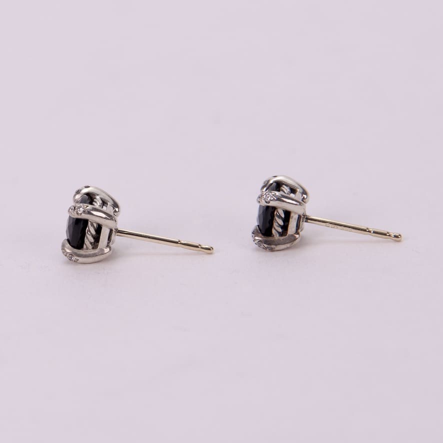 Silver earrings with black gemstone accents.