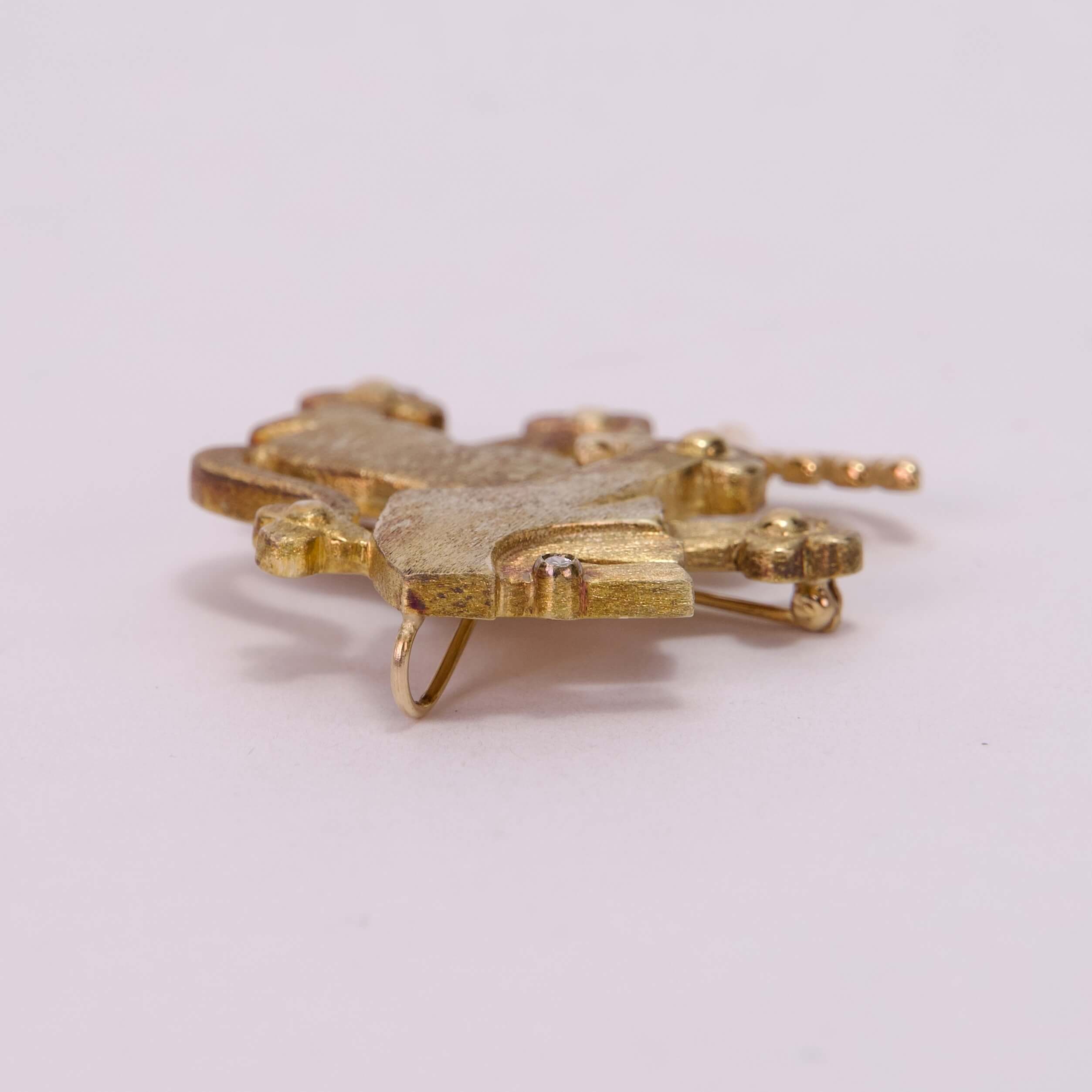 Gold-toned metal pin on white background.