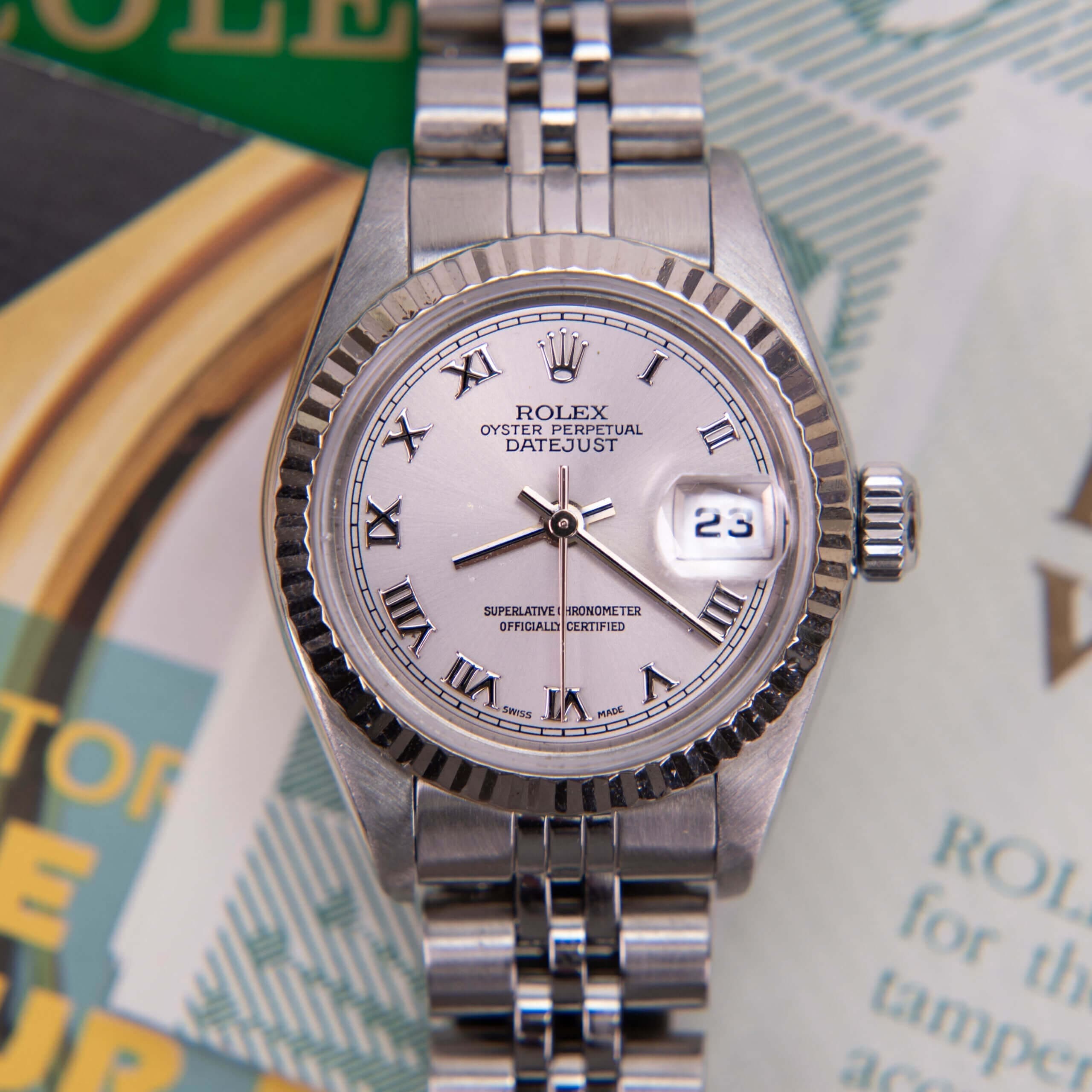 Silver Rolex Datejust watch with documents.