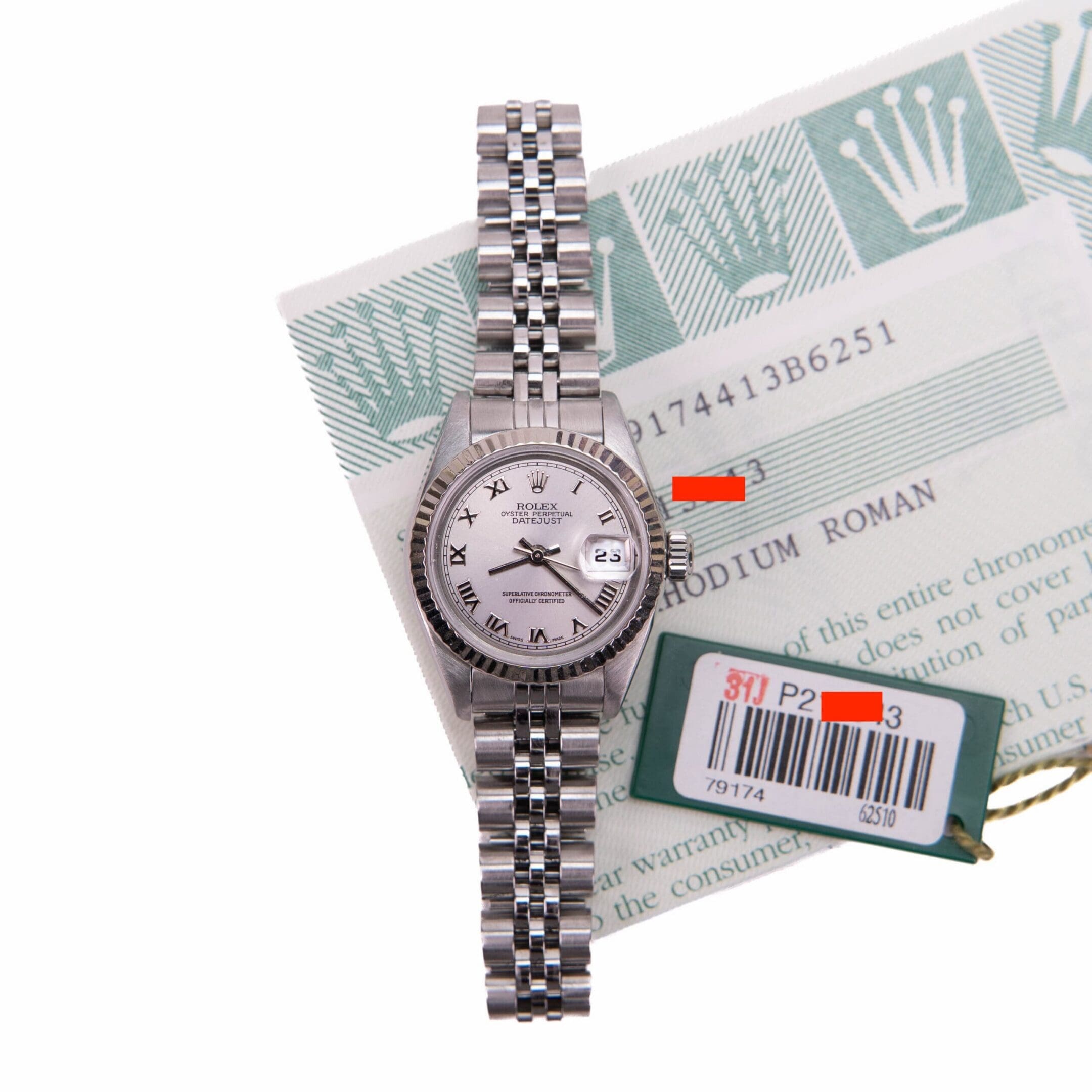 Luxury silver watch with documentation and tags.
