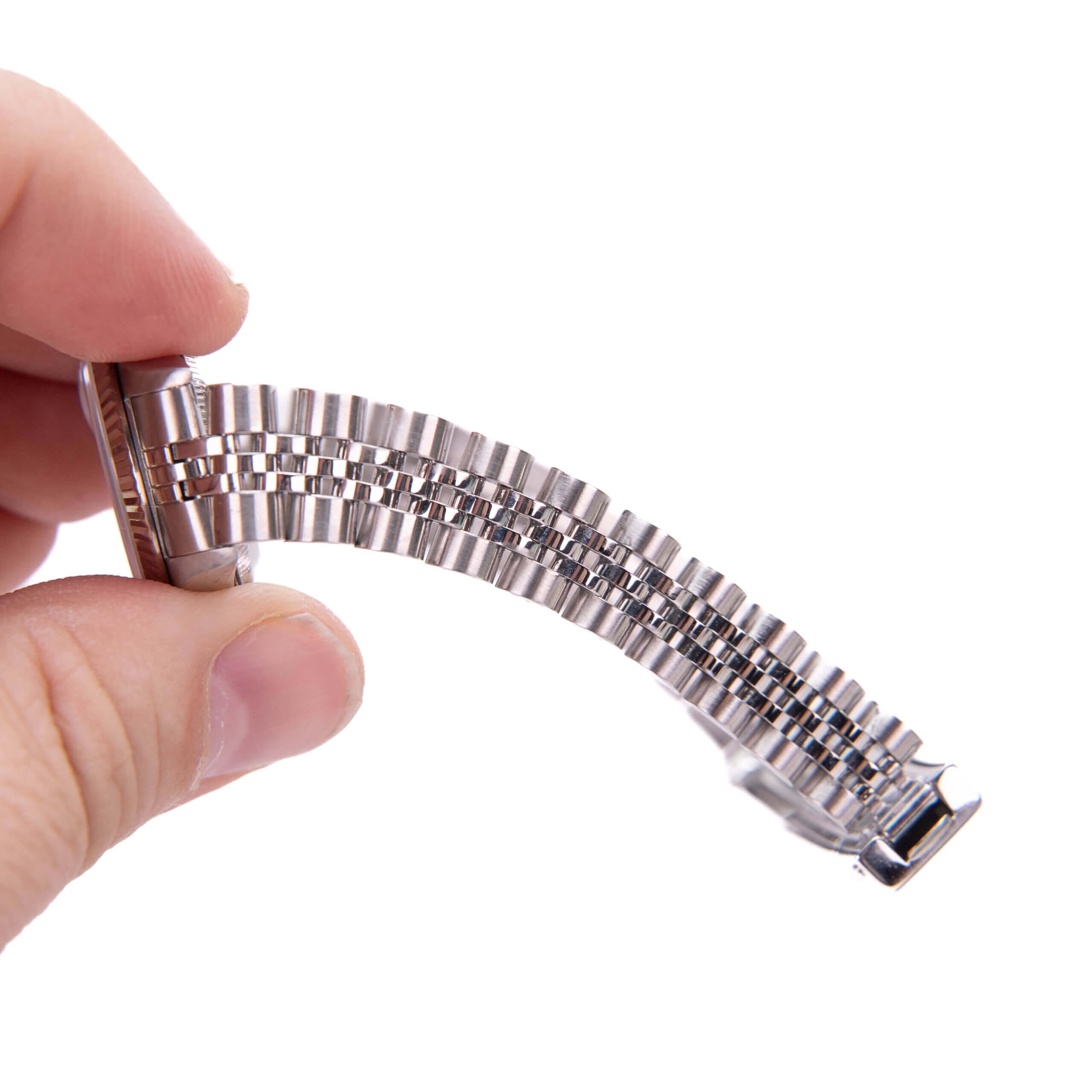 Hand holding a flexible metal watch bracelet.