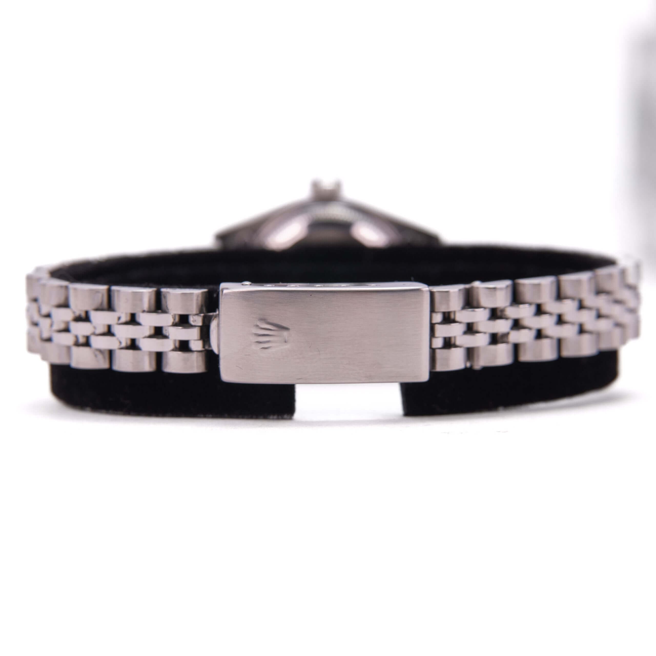Silver watch bracelet with black background.
