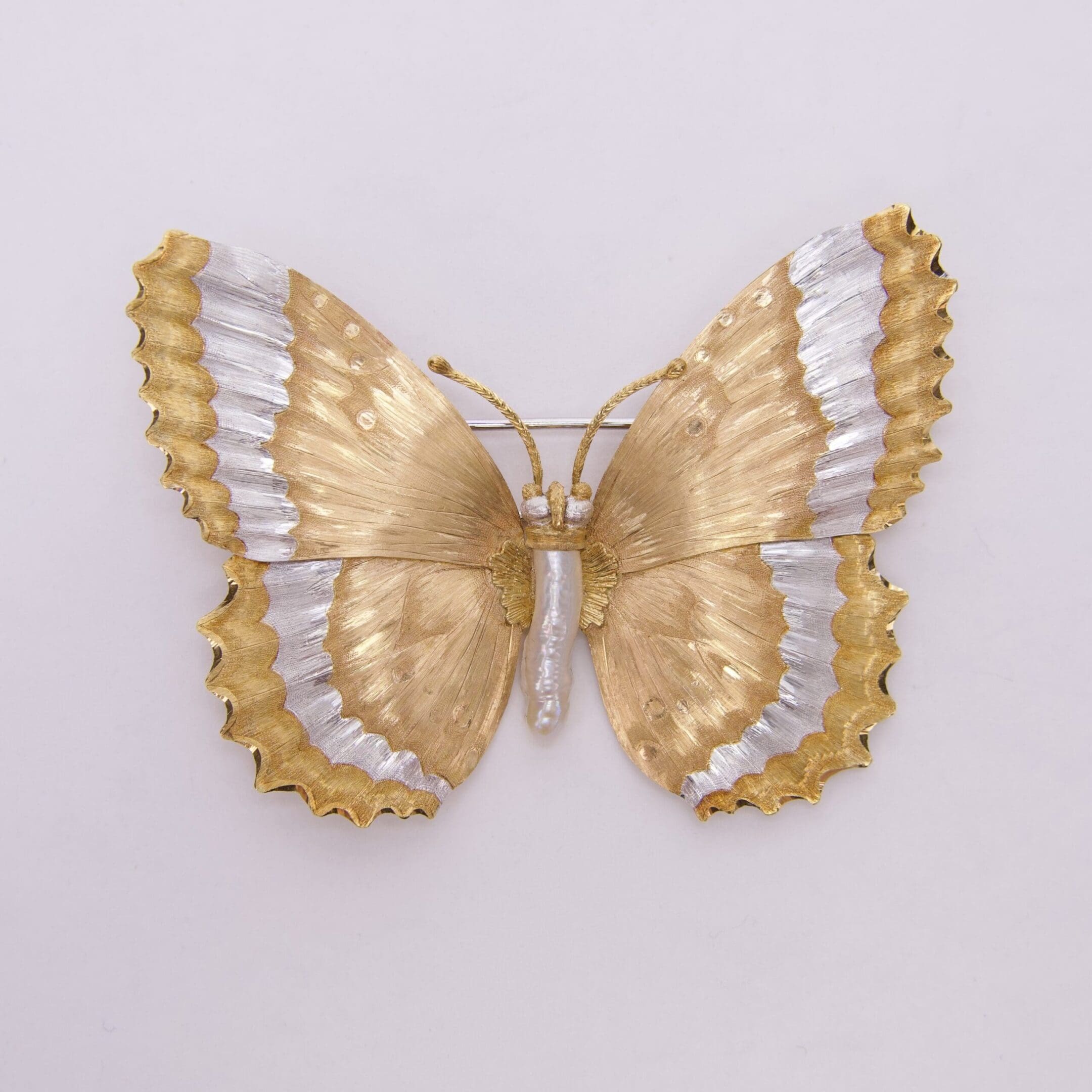 Golden and silver butterfly brooch on display.