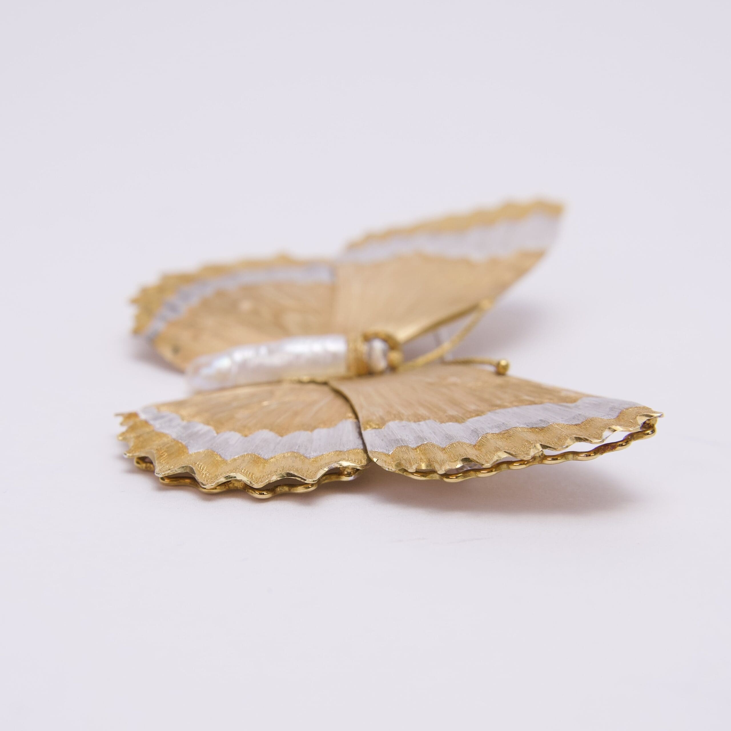 Gold and silver butterfly brooch on display.