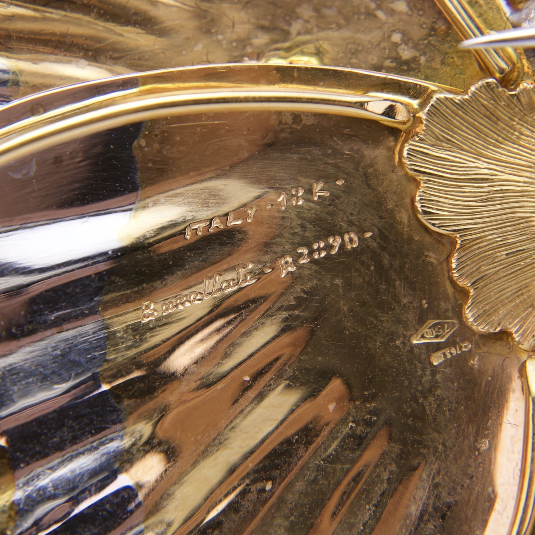 Gold object with embossed Italian markings.