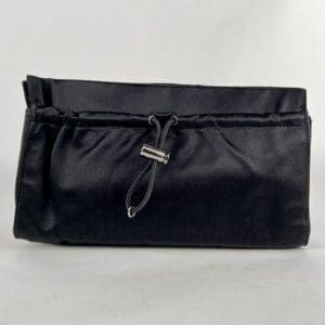 Black fabric clutch with drawstring closure.