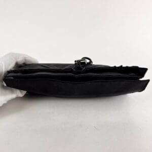 Black leather bag viewed from side.