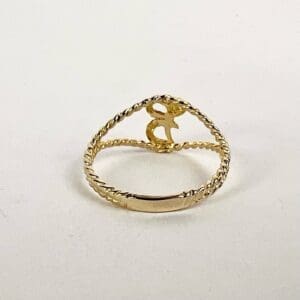 Gold ring with twisted band and letter.